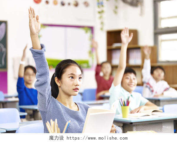 亚洲小学男生举手回答问题在教室里上课.